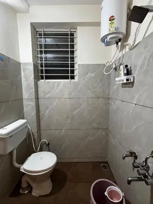 a small bathroom with a toilet and a window at Hazel's ELiTE Homestay 2bhk in Mysore