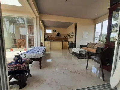 a living room with a couch and a table at GG Home stay in Pollāchi