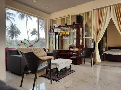 a living room with a couch and chairs and a bedroom at GG Home stay in Pollāchi