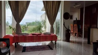 a bedroom with a red bed with a large window at GG Home stay in Pollāchi
