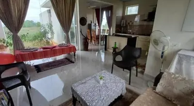 a living room with a couch and a table at GG Home stay in Pollāchi