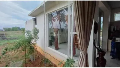 a window of a house with two vases in it at GG Home stay in Pollāchi