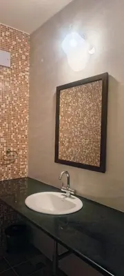 a bathroom with a sink and a mirror at Amblyn Home stay coorg in Madikeri