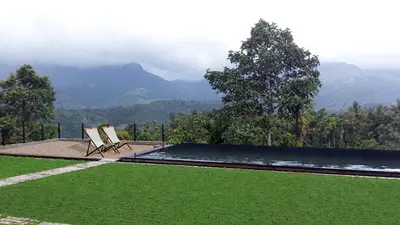 a pool with a chair and a view of mountains at Homestay Namaha in Meppādi