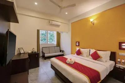 a hotel room with a bed and a television at Gokulam Grand Resort & Spa, Coorg in Kushālnagar