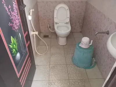 a small bathroom with a toilet and a sink at Blue Stones Service Apartment in Coimbatore