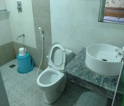 a bathroom with a toilet and a sink at Blue Stones Service Apartment in Coimbatore