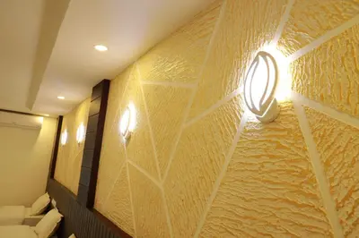a room with a wall covered in gold paper at Anna Residency in Nedumbassery