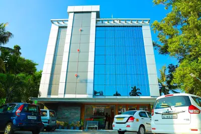 a building with cars parked in front of it at Anna Residency in Nedumbassery