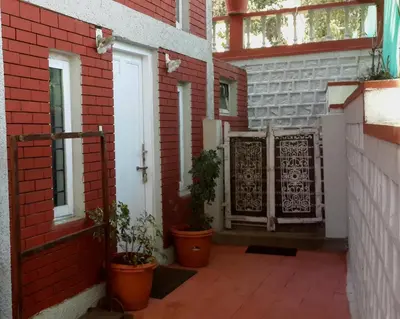 a courtyard of a house with potted plants on it at The Red House in Ooty