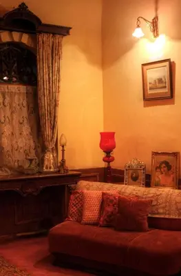 a bedroom with a bed and a red couch at The Red House in Ooty