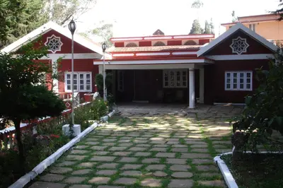 a house with a brick driveway in front of it at The Red House in Ooty