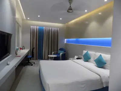 a hotel room with a white bed and a blue light at ZIBE Coimbatore by GRT Hotels in Coimbatore
