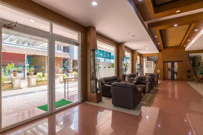 a waiting room with leather chairs and windows at Sree Gokulam Residency in Trichūr