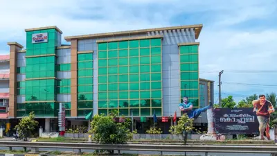 a large green building with people standing in front of it at Sree Gokulam Residency in Trichūr
