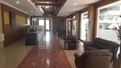 a lobby with couches and chairs in a building at Sree Gokulam Residency in Trichūr