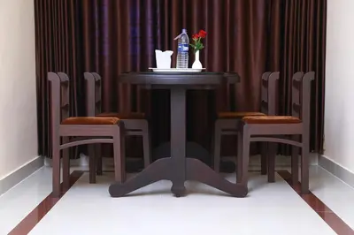 a table with chairs and a bottle of water on it at Orison Residency Hotel in Kunnamkulam