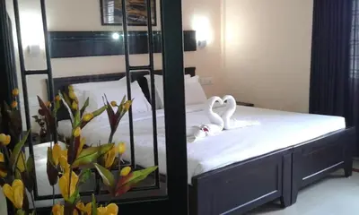 a bedroom with a bed with swans in a mirror at Orison Residency Hotel in Kunnamkulam