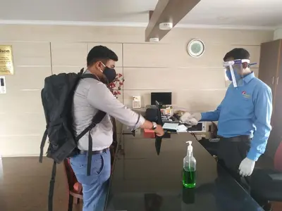 a man wearing a gas mask and a man in a room at Orison Residency Hotel in Kunnamkulam
