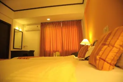 a hotel room with a large bed and a window at Sugam Hotel Pvt Ltd in Coimbatore