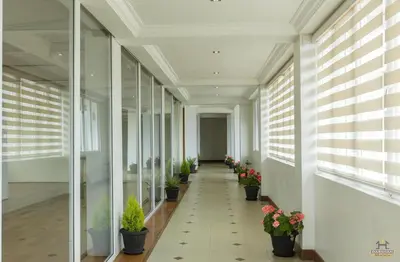 an empty hallway with potted plants in a building at Darshan Hotel in Ooty