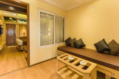 a living room with a couch and a window at Darshan Hotel in Ooty