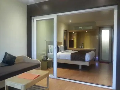 a bedroom with a bed and a living room at Darshan Hotel in Ooty