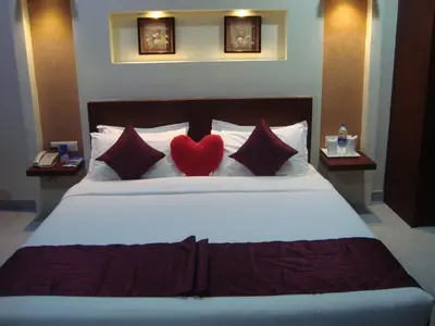 a bedroom with a bed with two hearts on the pillows at Rouba Residency Hotel in Ponnāni