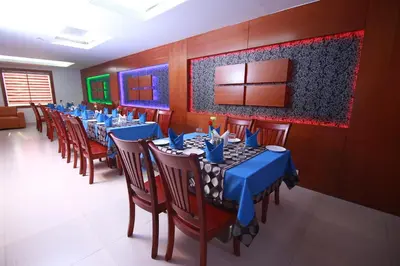 a dining room with blue tables and chairs at Rouba Residency Hotel in Ponnāni