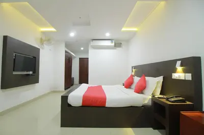 a bedroom with a bed with red and white pillows at Half Moon Residency Calicut in Kozhikode