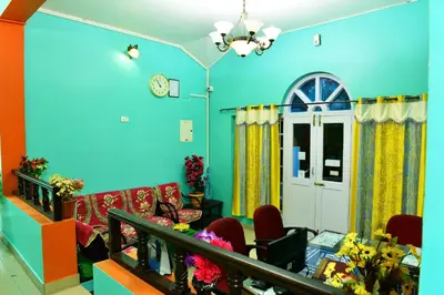 a living room with a blue wall at RK Holiday Home in Ooty
