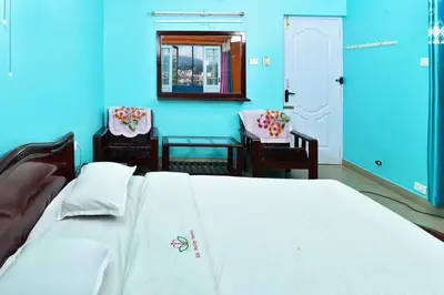 a bedroom with a white bed and a blue wall at RK Holiday Home in Ooty