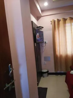 a room with a bathroom with a toilet and a television at hotel sangeeth lodging in Mysore