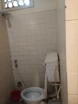 a small bathroom with a toilet in a room at hotel sangeeth lodging in Mysore