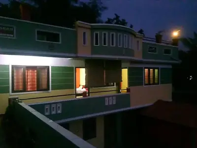 a large house at night with its lights on at Green Villa in Virajpet