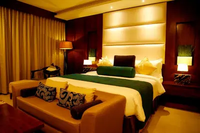 a hotel room with a large bed and a couch at The Raviz Calicut in Kozhikode