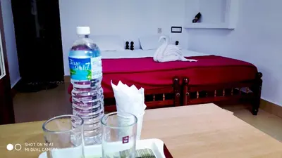 a bottle of water sitting on a table next to a bed at Cherai Ocean View Home in Cherai Beach