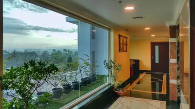 a room with a large window with potted plants at Seashore Residency in Kodungallūr