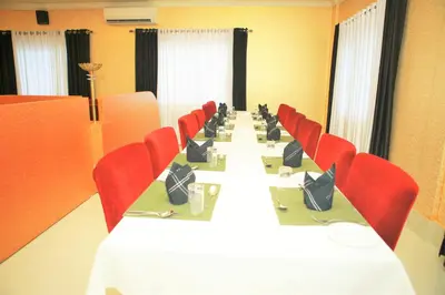 a conference room with a long table and red chairs at Seashore Residency in Kodungallūr