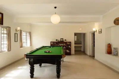 a living room with a pool table in a room at Colonels inn in Ooty