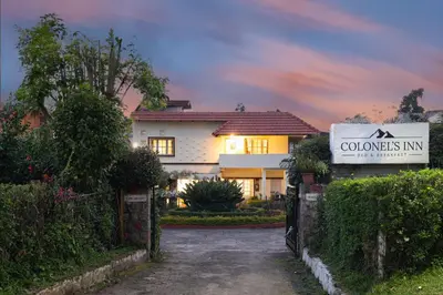 a house with a sign in front of a driveway at Colonels inn in Ooty