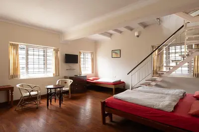 a bedroom with a bed and a stair case at Colonels inn in Ooty