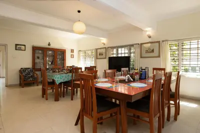 a dining room with a table and chairs at Colonels inn in Ooty
