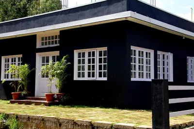 a black and white house with white windows at The Black Magic Cottage in Ooty