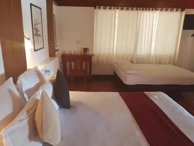a hotel room with two beds and a table at Petit Elephant in Cherai Beach