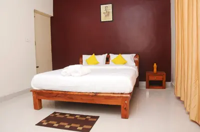 a bedroom with a bed with white sheets and yellow pillows at Holidayincoorg Orchid Villa in Madikeri