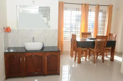 a kitchen and dining room with a sink and a table at Holidayincoorg Orchid Villa in Madikeri