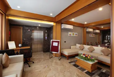 a living room with a couch and a desk at Hotel Park Residency Calicut in Kozhikode