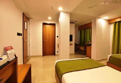 a hotel room with a bed and a living room at Hotel Park Residency Calicut in Kozhikode
