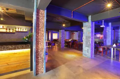 a dining room with tables and chairs and blue lighting at Hotel Park Residency Calicut in Kozhikode